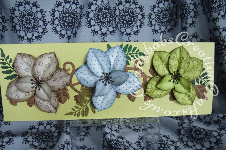 Tattered Lace Flowers from leaves. These dimensional flowers were made using the Tattered Lace Lavish Blooms leaves dies cut from patterned papers. These were then embossed with different embossing folders then inked and shaped to form flowers. Tattered Lace Lavish Blooms fern leaf used to accent, background vine from Spellbinders On The Vine (12" die) - craftybabscreativecrafts.co.uk