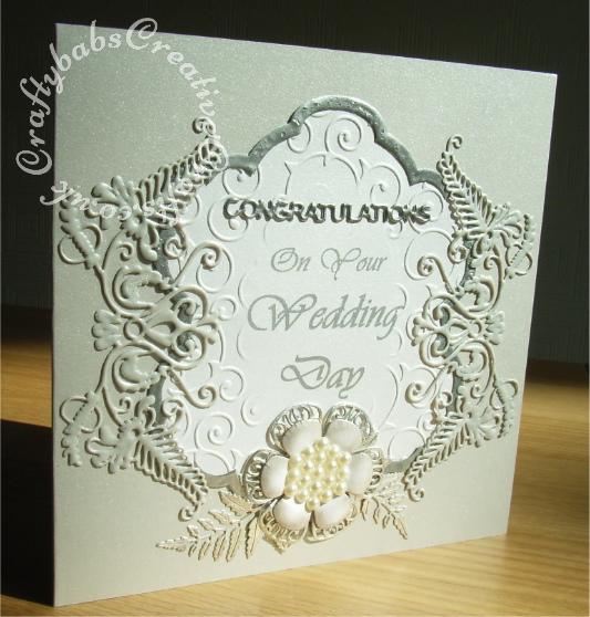 Wedding card made using Tattered Lace Venetian Fern die, Tattered Lace Venetian Fern Frame die, Tattered Lace Lavish Blooms Poppy die and Tattered Lace Lavish Blooms fern die. Background embossed with flourish swirl embossing folder and Tim Holtz embossing diffuser oval, Sentiment Tattered Lace Congratulations dies and remainder printed - craftybabscreativecrafts.co.uk
