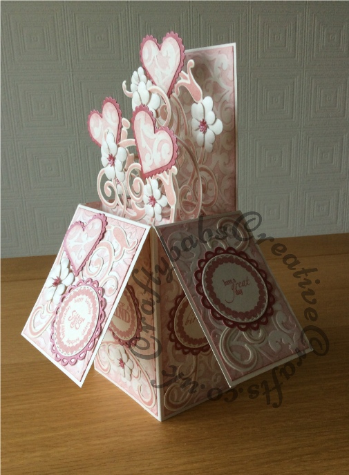 Pop up birthday cardmade using a number of dies including; Spellbinders nesting plain and scalloped hearts dies, Cheery lynn flowers dies, Anna griffin flourish scroll die, spellbinders lacey circles dies, Crea Nest lies no 33 dies, leabilities frame square curve die set (for small flourishes). Background embossed with distress ink applied to folder using embossaliscious a4 folder. Sentiments stamped in matching distress ink (Victorian velvet) - craftybabscreativecrafts.co.uk