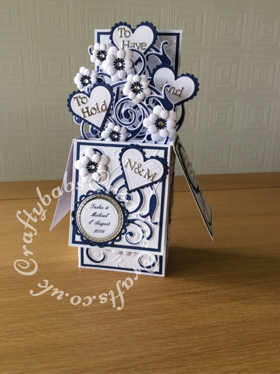 Pop up Wedding card made using a number of dies including; Spellbinders nesting plain and scalloped hearts dies, Cheery lynn flowers dies, Anna griffin flourish scroll die, spellbinders lacey circles dies, Crea Nest lies no 33 dies, leabilities frame square curve die set (for small flourishes). Joy cut & emboss wedding die set, Background embossed with Xcut A4 folder. Die cuts inked whilst in die in matching distress ink (Chipped Sapphire) - craftybabscreativecrafts.co.uk