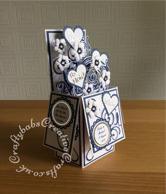 Pop up Wedding card made using a number of dies including; Spellbinders nesting plain and scalloped hearts dies, Cheery lynn flowers dies, Anna griffin flourish scroll die, spellbinders lacey circles dies, Crea Nest lies no 33 dies, leabilities frame square curve die set (for small flourishes). Joy cut & emboss wedding die set, Background embossed with Xcut A4 folder. Die cuts inked whilst in die in matching distress ink (Chipped Sapphire) - craftybabscreativecrafts.co.uk