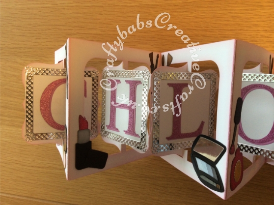 Accordion flip 21st Birthday card made using Sizzix Bigz accordion flip 3d die, frames cut with Tattered Lace Chatsworth square die, Lettering cut with Quickutz Mary Jane cookie cutter alphabet dies. Make up items cut using various dies icluding Quickutz cookie cutters from the 'Flirt' set, Ellison thin cut eye make up die, Sizzix sizzlits Glam girl set, Quickuts 2 x 2 Eye Make up and lipstick dies. Sentiments cut using Tattered lace sentiment dies and Britannia sentiment dies - craftybabscreativecrafts.co.uk