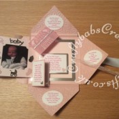 Baby Girl Birth keepsake made using a variety of dies including Quickutz nesting Tag dies, Ellison thick cutz envelope die, Cuttlebug baby elements die, Marianne baby feet dies, Memory Box pram die, nesting plain & scalloped oval dies, Memory box alphabet soup upper and lower case dies, Parchment pocket made using an envelope template stencil, baby clothes and baby words embossed using brass stencils, outer cover embossed using couture creations intrinsic embossing folder - craftybabscreativecrafts.co.uk