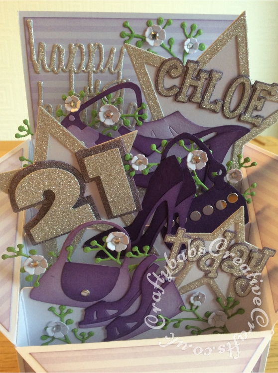 Large Pop Up Shoes & Bags themed 21st Birthday card made from 8"x8" card blank. Numerous dies used including; Sizzix Framelits Stars/ Primitive Die Set, Sizzix sizzlits 'Girls Are Weird' alphabet dies, Sizzix originals Shadow Box numbers, Sizzix sizzlits small purses and shoes set and shoes set, Ellison window cuts handbag, Cheery Lynn Baby's breath flower set, MCS sprig dies (from The Works) and Sentiment die cut using 660223 Sizzix Thinlits Die Set 13PK - Celebration Words Script by Tim Holtz - craftybabscreativecrafts.co.uk