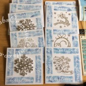 Batch making Christmas cards, made using Stamps Away Patchwork Template set One, Memory Box - A6 Stencil - Script Merry and various dies to embellish including Tattered Lace Let It Snow (D447), Tattered Lace Leaping Reindeer die, Ultimate Carfts Snowball die, and snow flakes from Hunkydory Christmas boxed kit. Some cards embellished with Christmas tree ornaments. All cards coloured by inking through stencils with various shades of blue distress inks - craftybabscreativecrafts.co.uk