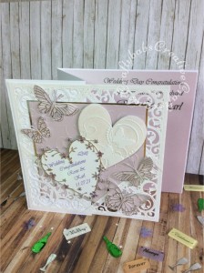8″ square Wedding card made using included Spellbinders Gold Elements dies, Memory Box Kaleidoscope, moonlight, Pippi, Isabella, Vivienne and Darla butterflies, Bingham and Grand Heart dies. Background embossed with Darice embossing folder then heat embossed over iridescent mica powder. - craftybabscreativecrafts.co.uk