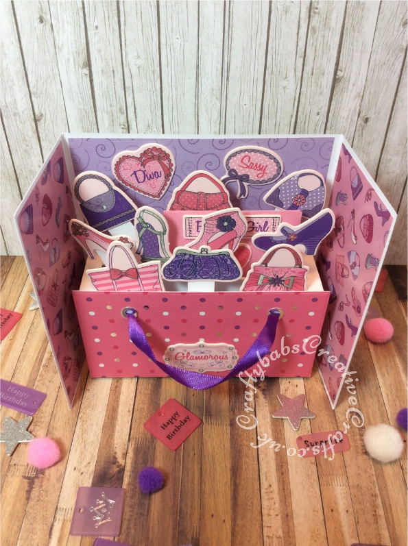 Pop up 21st birthday card inspired by Sam Calcott of Mixed Up Crafts. I didn't have the Made to Surprise dies to make this but managed to make my own mechanism using a scoreboard and craft knife. I used a old pack of chip board embellishments that has been in my stash for years, they came with coordinating papers too. I die cut the numbers using unbranded layered numbers dies. - craftybabscreativecrafts.co.uk