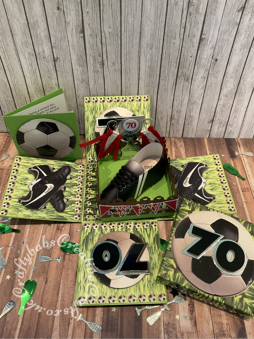 Football themed 70th Birthday Exploding box card made using an old kit and embellished with various dies including Sizzix Originals Shadow Box number dies, Tattered lace Bunting 2018 die, Tattered lace Championship die set (for trophy) La La Lande Heart fence die, Memory Box alphabet soup alphabet dies. Nesting circles dies and Hunky Dory Moonstone sentiments dies. Glossy accents applied to football boots and footbal decoupage elements. - craftybabscreativecrafts.co.uk