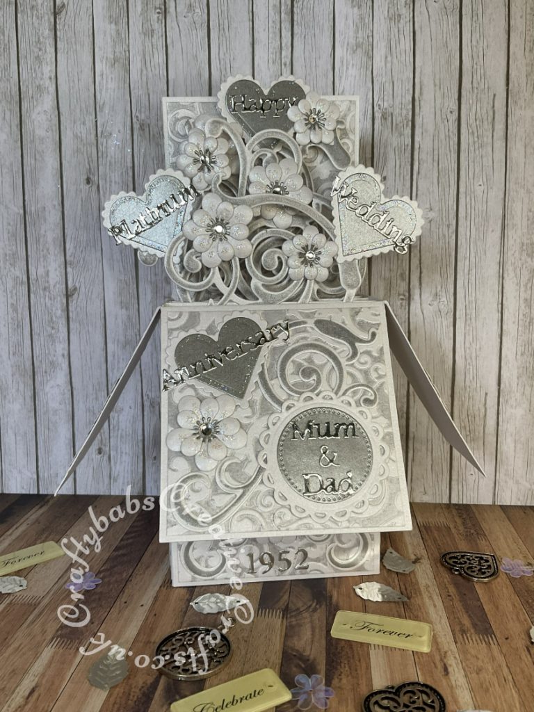 Pop up Wedding card made using a number of dies including; Spellbinders nesting plain and scalloped hearts dies, Cheery lynn flowers dies, Anna griffin flourish scroll die, spellbinders lacey circles dies, Crea Nest lies no 33 dies, leabilities frame square curve die set (for small flourishes). Joy cut & emboss wedding die set, Background embossed with Xcut A4 folder. Die cuts inked whilst in die in matching distress ink (Hickory Smoke) - craftybabscreativecrafts.co.uk
