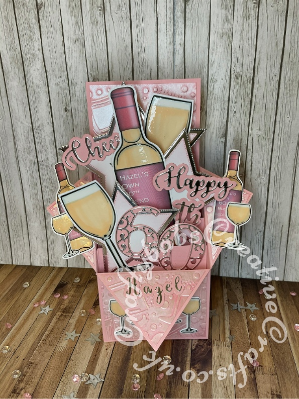 Rose Wine Pop Up Box 60th birthday card made using various digi-stamps from Craftworld Premium members free digi-stamps cheers collection, dies including; CARD MAKING MAGIC DIE SETS SOLID & OVERLAY NUMBER & SUFFIX, i Craft Cheers & Happy dies, embossing folder and stamps from Issue 161 of Simply cards & Papercraft magazine, Gemini Expressions Metal Die – Uppercase and lower case Alphabet Sets. - craftybabscreativecrafts.co.uk
