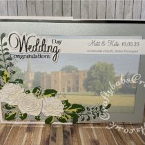 Extra Large A4 Double Z fold Wedding card made usin a partially faded photograph of the wedding venue and decorated with various dies including:- Card making Magic Die Set Christmas Rose by Christina Griffiths, Alt-e-new Layered Rose die set, free with issue 174 of Simply Cards & Papercraft magazine, Berry Foliage die (no name but bought from The Works), Pair of Ferns by Cheery Lynn Designs Dies, Tattered Lace sentiment 2014 dies and Joy Craft Cutting Dies – Wedding (6002/0395.- craftybabscreativecrafts.co.uk
